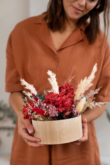 Vue de face femme souriante tenant des fleurs