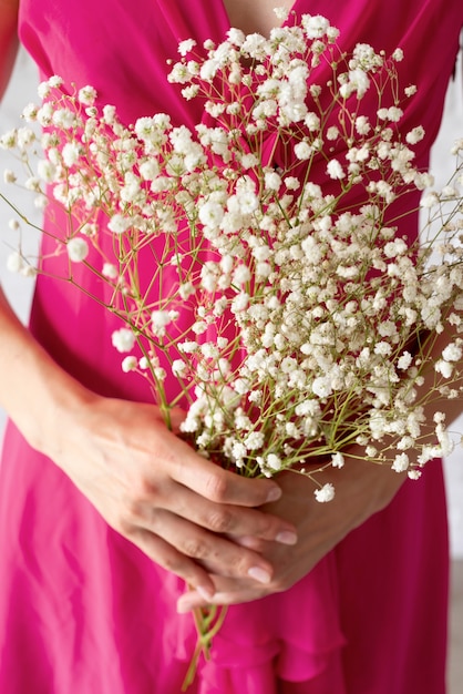 Photo gratuite vue de face d'une femme tenant un bouquet de fleurs