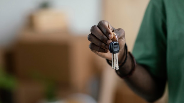 Photo gratuite vue de face de la femme tenant les clés de sa nouvelle maison