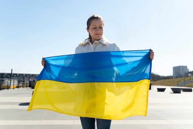 Photo gratuite vue de face femme tenant le drapeau ukrainien