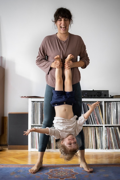 Photo gratuite vue de face femme tenant un enfant à l'envers