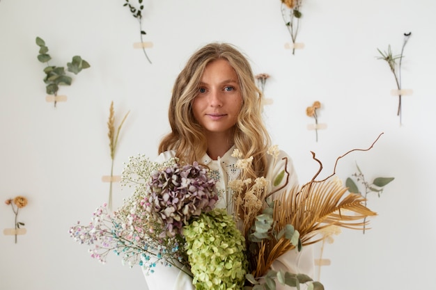 Photo gratuite vue de face femme tenant des fleurs séchées