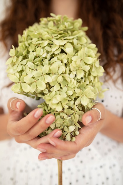 Vue de face femme tenant des fleurs séchées