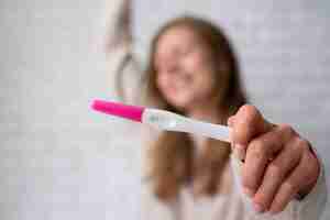 Photo gratuite vue de face femme tenant un test de grossesse positif