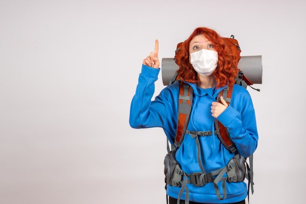 Vue de face femme touriste aller en montagne en masque avec sac à dos