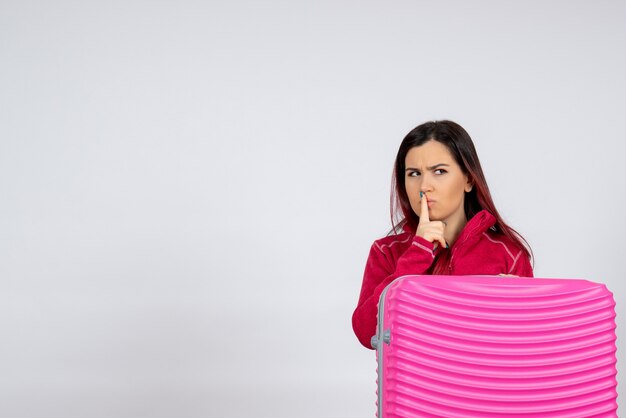 Vue de face femme touriste avec sac rose sur mur blanc