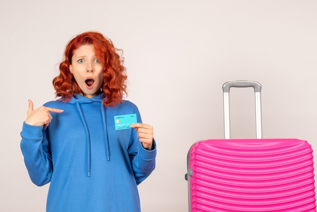 Vue de face femme touriste avec sac rose et tenant une carte bancaire