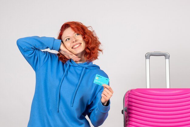 Vue de face femme touriste tenant une carte bancaire et souriant