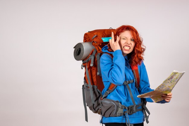 Vue de face de la femme touriste en voyage en montagne avec carte et carte bancaire