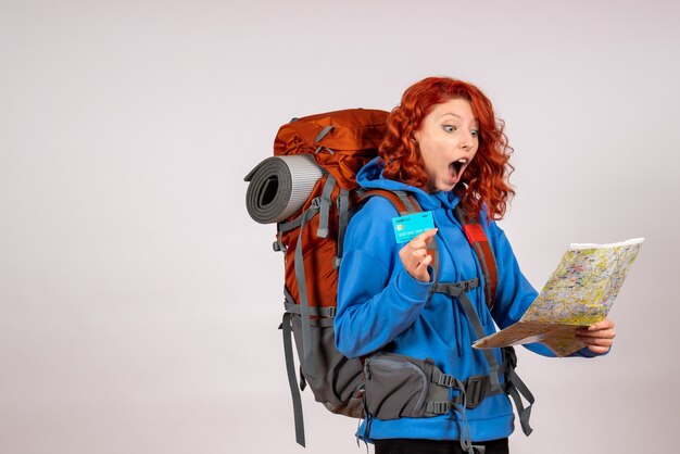 Vue de face de la femme touriste en voyage en montagne avec carte et carte bancaire