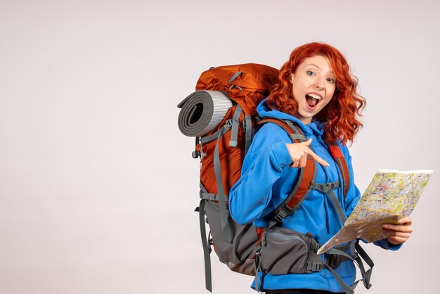 Vue de face femme touriste en voyage en montagne avec sac à dos et carte