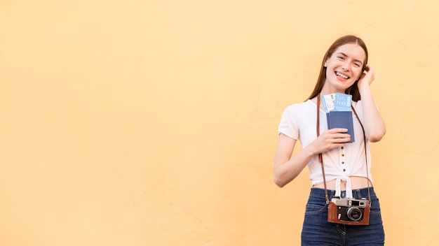 Vue de face de la femme touristique avec passeport et appareil photo