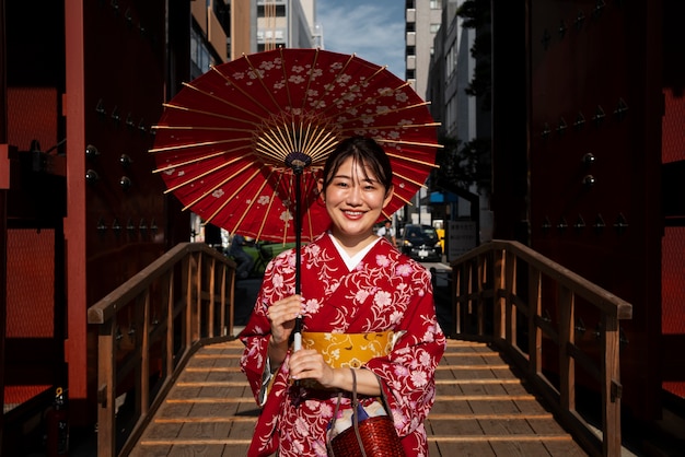 Vue de face femme utilisant un parapluie wagasa