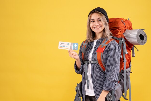 Vue de face de la femme de voyageur joyeux avec sac à dos tenant un billet