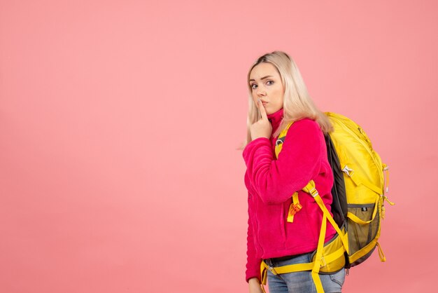 Vue de face femme voyageur avec sac à dos faisant signe de silence