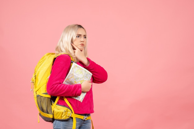 Vue de face femme voyageur avec sac à dos tenant la carte penser à quelque chose