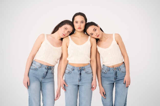 Vue de face de femmes en débardeurs et jeans posant dans des portraits minimalistes