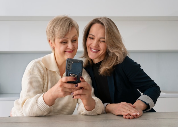 Photo gratuite vue de face des femmes lisant des messages sur un téléphone portable