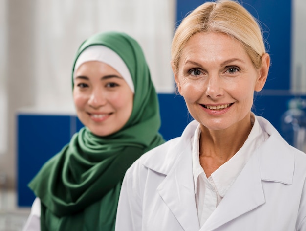 Vue de face de femmes scientifiques posant dans le laboratoire