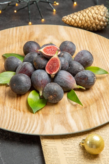 Vue de face des figues douces fraîches à l'intérieur de la plaque sur fond sombre