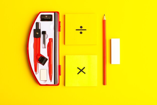 Vue de face des figures géométriques avec des autocollants et un crayon sur une surface jaune