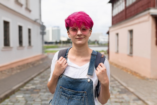 Vue de face fille aux cheveux roses posant