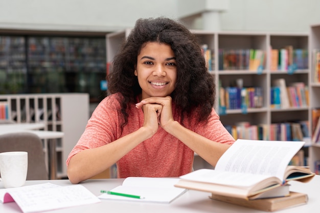 Vue de face fille à la bibliothèque étudier