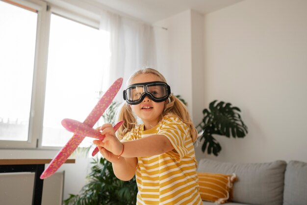 Vue de face fille jouant avec avion