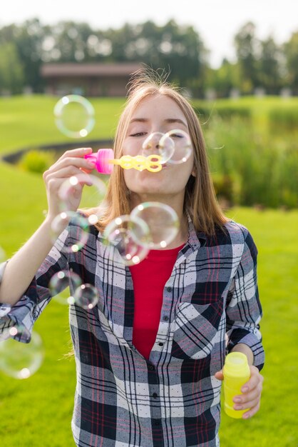 Vue de face fille jouant avec des bulles de savon