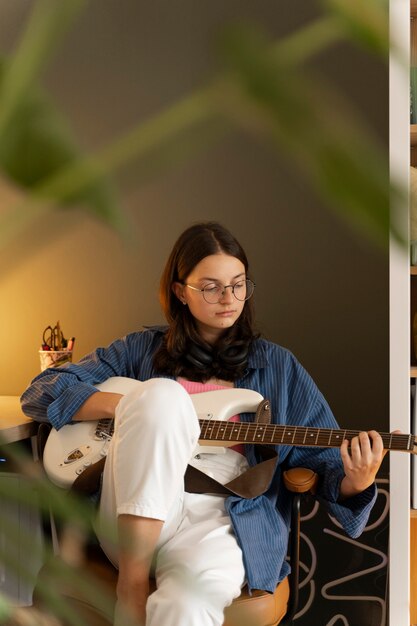 Vue de face fille jouant de la guitare