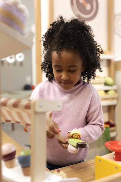 Vue de face fille jouant avec des jouets écologiques