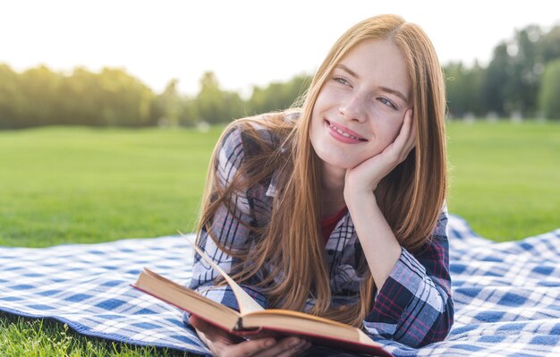 Vue de face fille avec un livre à la recherche de suite