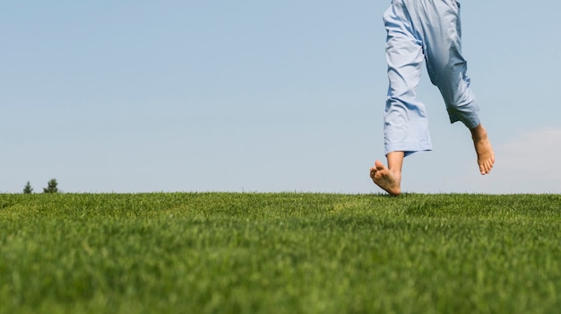 Photo gratuite vue de face fille marchant sur l'herbe