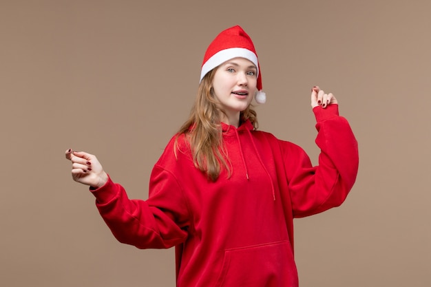 Vue de face fille de noël danse sur fond marron femme vacances noël