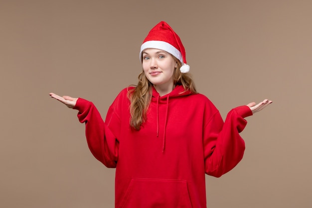 Vue de face fille de Noël pensant sur le modèle de fond marron vacances Noël