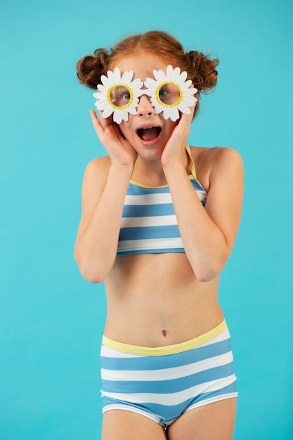 Vue de face fille posant avec des lunettes de soleil