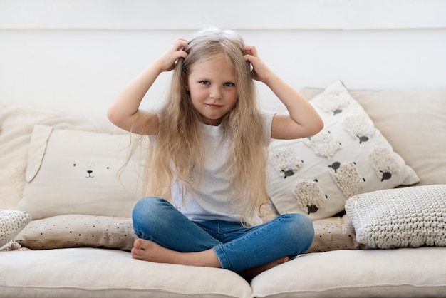 Photo gratuite vue de face fille avec des poux sur le canapé