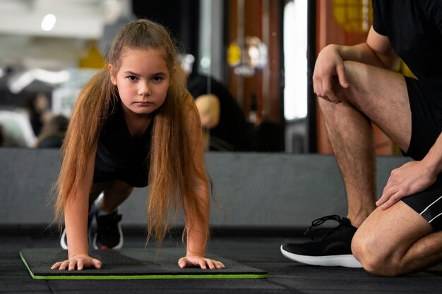 Vue de face fille s'entraînant au gymnase