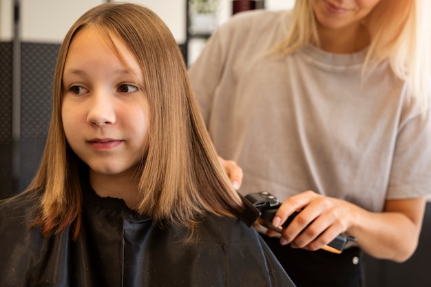 Photo gratuite vue de face fille se coupe les cheveux au salon