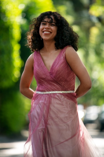 Vue de face fille souriante posant à l'extérieur