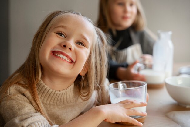 Photo gratuite vue de face fille souriante tenant un verre