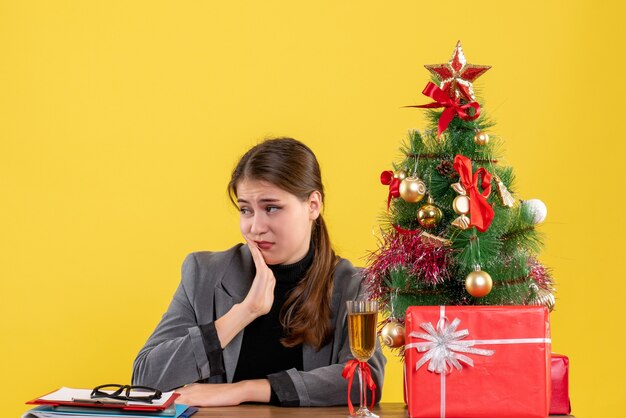 Vue de face fille triste assise à la table mettant la main