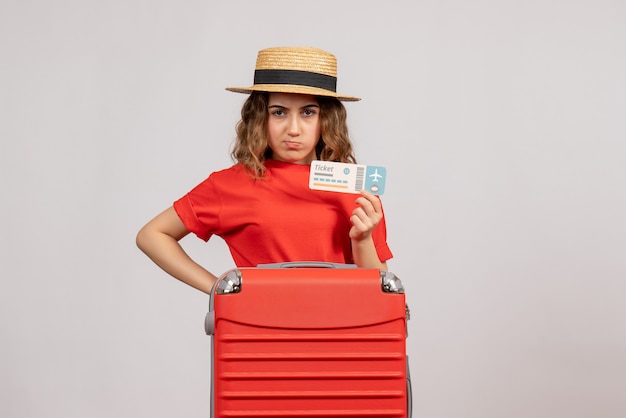 Vue de face de la fille de vacances grincheux avec son billet valise holding