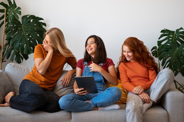 Vue de face filles riant d'un ami