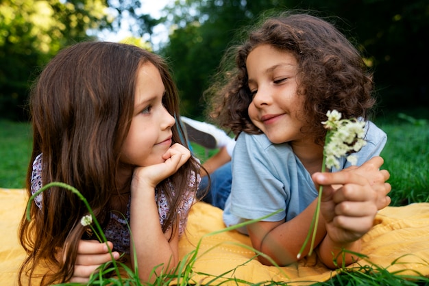 Photo gratuite vue de face filles tenant des fleurs