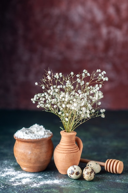 Vue de face des fleurs blanches avec des œufs de caille et de la farine sur fond sombre beauté arbre photo couleur nature nourriture oiseau