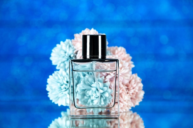 Vue de face des fleurs de bouteille de parfum sur fond bleu flou photo stock