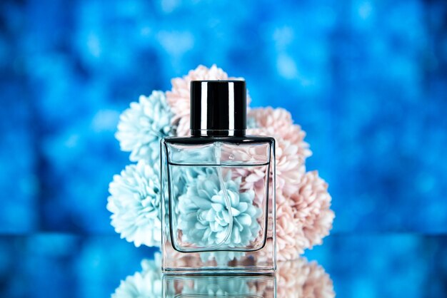 Photo gratuite vue de face des fleurs de bouteille de parfum sur fond flou bleu