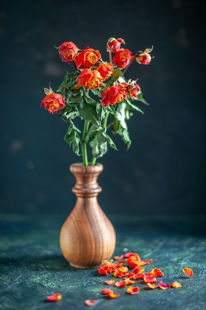 Vue de face des fleurs fanées rouges sur une surface sombre