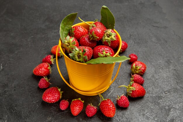 Vue de face fraises rouges fraîches sur le fond sombre